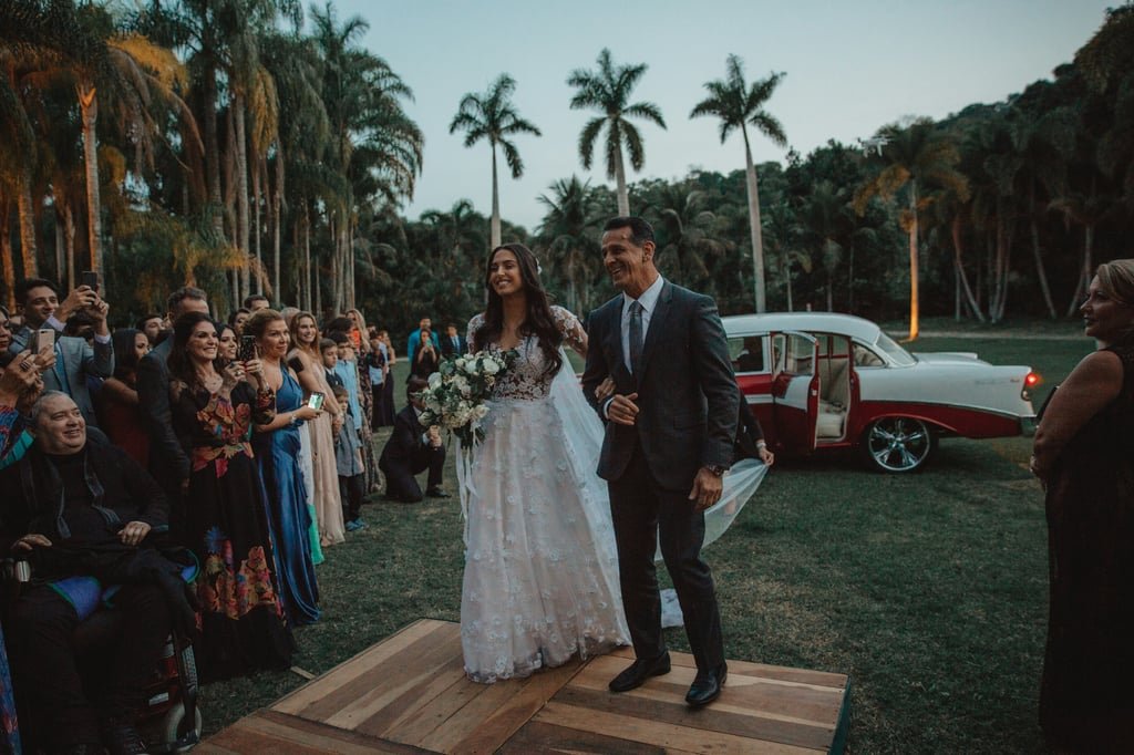 A couple walking down the aisle among palms