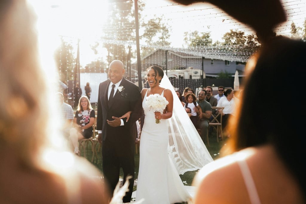 A bride and groom walking through their guests